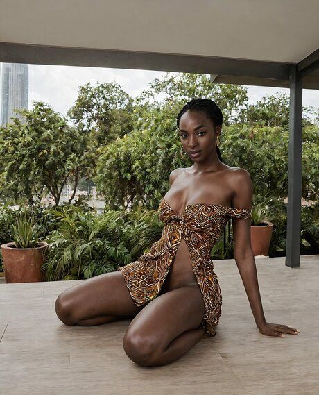 Pretty black girl with her hair braided stands naked on a rooftop patio - #3