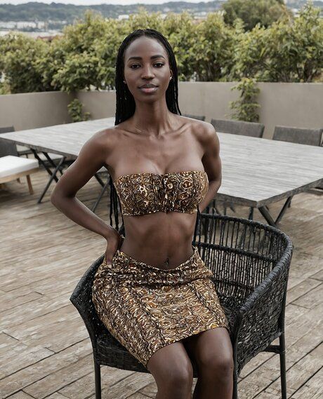 Pretty black girl with her hair braided stands naked on a rooftop patio - #2